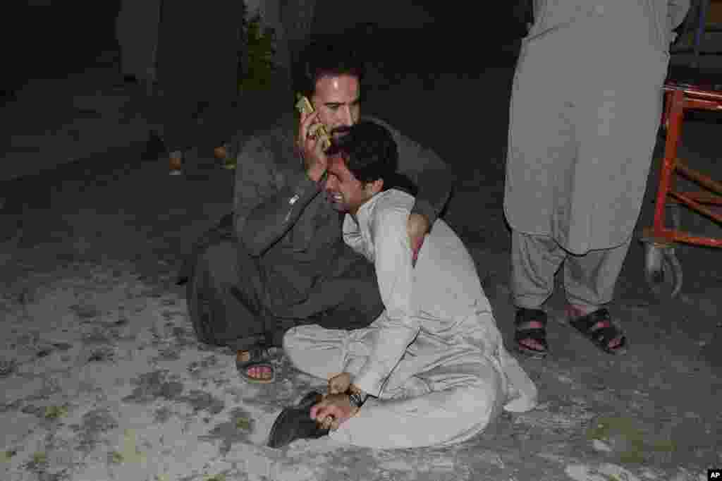 A Pakistani comforts to another mourning over the death of his family member in a bomb blast, at a hospital in Quetta, April 21, 2021.&nbsp;A powerful bomb went off in the parking area of a five-star Serena hotel in the southwestern city, wounding some people, police said.