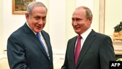 Russian President Vladimir Putin, right, shakes hands with Israeli Prime Minister Benjamin Netanyahu during their meeting at the Kremlin in Moscow, July 11, 2018.
