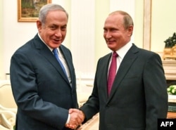 Presiden Rusia Vladimir Putin (kanan) berjabat tangan dengan Perdana Menteri Israel Benjamin Netanyahu dalam pertemuan di Kremlin, Moskow, 11 Juli 2018.
