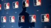 FILE - A MLB logo backdrop is seen at a press conference in Phoenix, Arizona, Feb. 23, 2015.