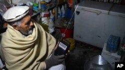 FILE - An Afghan shopkeeper listens to Islamic State Radio at his shop in Jalalabad, capital of Nangarhar province, Afghanistan, Jan. 10, 2016.