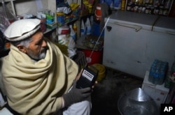 FILE - An Afghan shopkeeper listens to Islamic State Radio at his shop in Jalalabad, capital of Nangarhar province, Afghanistan, Jan. 10, 2016.