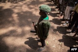 Serdadu anak yang baru dibebaskan bersiaga dengan senjatanya dalam upacara pembebasan di Yambio, Sudan Selatan, 7 Desember 2018.