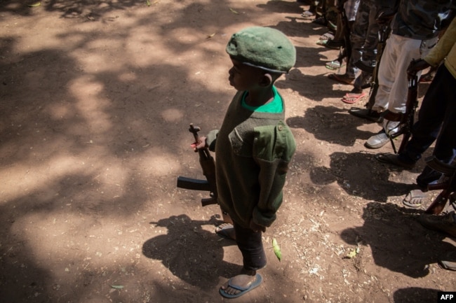 Serdadu anak yang baru dibebaskan bersiaga dengan senjatanya dalam upacara pembebasan di Yambio, Sudan Selatan, 7 Desember 2018.