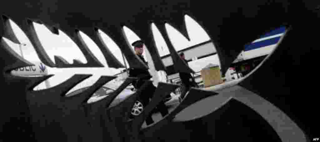 A police officer stands guard, behind the logo of Cannes, outside the media center of the G20 in Cannes, France on Wednesday, Nov. 2, 2011. French President Nicolas Sarkozy will hold emergency talks Wednesday with European leaders in a last-ditch bid to s