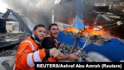 Palestinski vatrogasci na području Gaze gase požar u fabrici sunđera (Foto: REUTERS/Ashraf Abu Amrah)