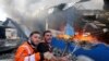 Des pompiers palestiniens essayent d'éteindre le feu dans une usine d'éponges après des tirs d'obus israéliens dans le nord de la bande de Gaza le 17 mai 2021. 