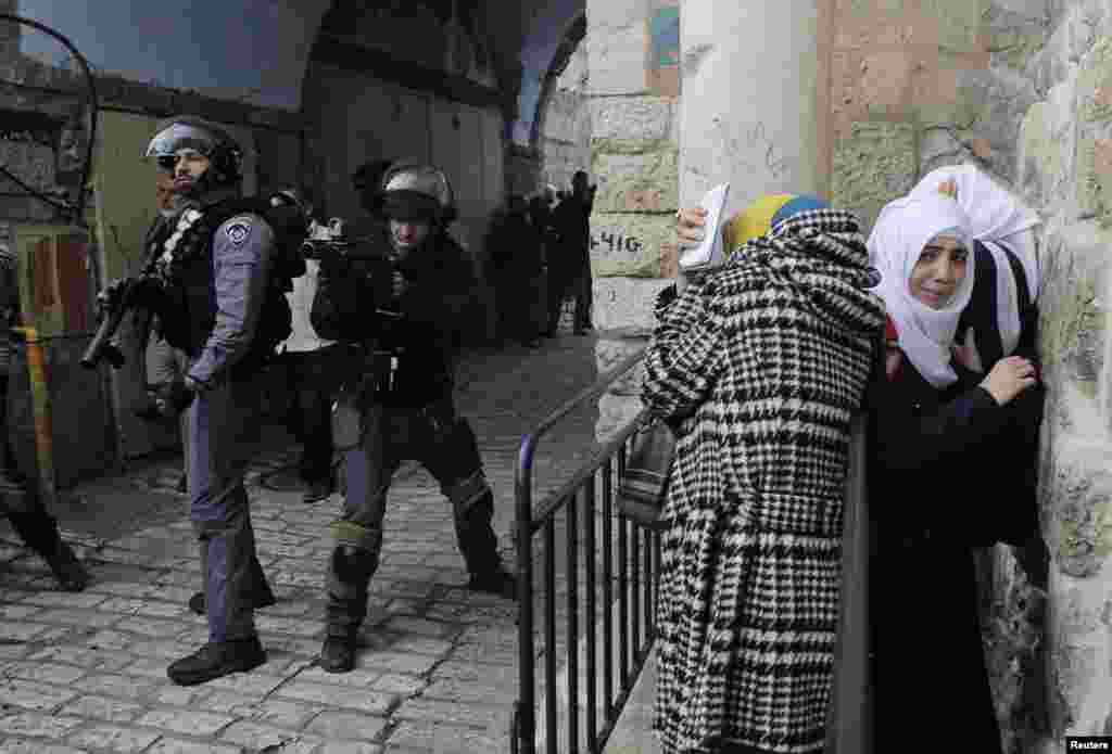 Palestinian women take cover as Israeli police use stun grenades to disperse a crowd trying to enter the compound known to Muslims as the Noble Sanctuary and to Jews as the Temple Mount in Jerusalem&#39;s Old City, Nov. 5, 2014. 