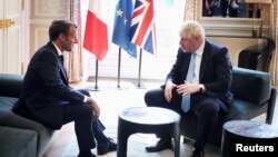 Presiden Perancis Emmanuel Macron (kiri) menerima Perdana Menteri Inggris Boris Johnson di Istana Elysee, Paris hari Kamis (22/8). 