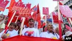 Russian Communist party supporters carry a banner reading "55 - and no minute more" as they take part in a rally against the government's proposed reform hiking the pension age in Moscow, Sept. 2, 2018. 