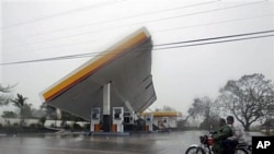 Motorists drive past a filling station which was toppled by typhoon Megi (local name "Juan"), 18 Oct 2010, at Cauayan, Isabela province, northeastern Philippines