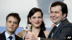 FILE - From left, director Sebastian Lelio, actress Daniela Vega and writer Gonzalo Maza pose for the photographers with their Best Screenplay silver bear for the film "A Fantastic Woman" during the award winners press conference at the 2017 Berlin International. (AP Photo/Michael Sohn)