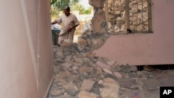 FILE - A man inspects his house damaged after a bomb attack by Islamic State group extremists in Khalidiya, 60 miles (100 kilometers) west of Baghdad, Sept. 20, 2015.