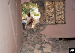 A man inspects his house damaged after a bomb attack by Islamic State group extremists in Khalidiya, 60 miles (100 kilometers) west of Baghdad, Iraq, Sept. 20, 2015.