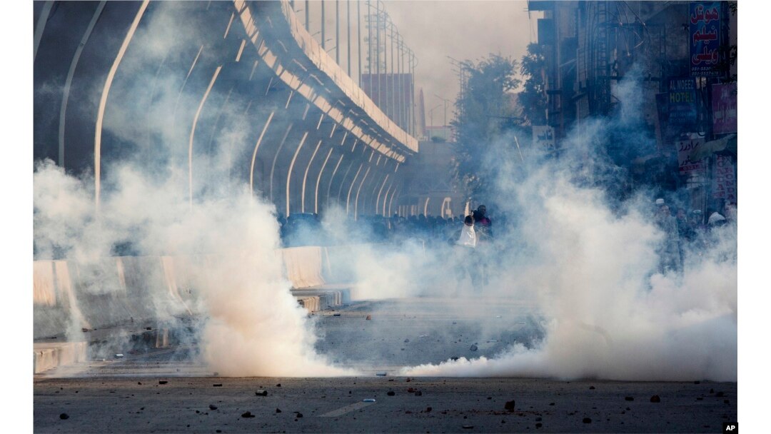 Police fire tear gas to disperse crowd protesting against the government in Rawalpindi, Pakistan, Friday, Oct. 28, 2016.