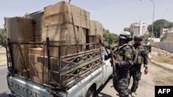 Поліція перевіряє машину після кількох вибухів у Багдаді
