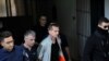 Александр Винник, россиянин, подозреваемый в проведении операции по отмыванию денег с использованием биткойнов, в сопровождении полицейских выходит из суда в Салониках, Греция. 11 октября 2017 года.
