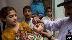 A Pakistani health worker gives a polio vaccine to a child in Rawalpindi, Pakistan, Tuesday, May 6, 2014. Pakistan’s health minister says the country is taking extra ordinary measures to meet the new situation it is going to face after polio travel restri