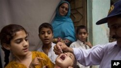 Petugas kesehatan memberikan vaksin polio kepada anak-anak di Pakistan (foto:dok).