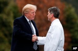 FILE - President Donald Trump shakes hands with then-White House physician Dr. Ronny Jackson as he leaves Walter Reed National Military Medical Center in Bethesda, Maryland, Jan. 12, 2018, after his first medical check-up as president.