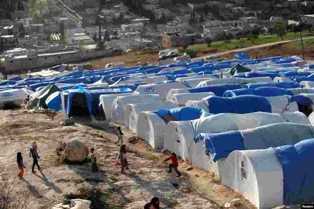 Anak-anak di Suriah bermain di luar tempat tinggal darurat mereka di kamp pengungsi Qah, desa Atme, provinsi Idlib (17/3).