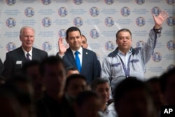 Guatemala's President Jimmy Morales, center, stands between Guatemala City Mayor Alvaro Arzu, left, and Villa Nueva Mayor Edwin Escobar during a meeting with city mayors in Guatemala City, Aug. 29, 2017.