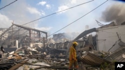 Un bombero camina entre los escombros dejados por una explosión en una fábrica de plásticos Polyplas, en el vecindario de Villas Agrícolas, en Santo Domingo, República Dominicana. Diciembre 5 de 2018.