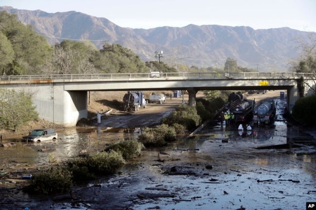 Crews work on clearing Highway 101 in the aftermath of a mudslide, Jan. 13, 2018, in Montecito, Calif. Most of the people of the town, usually known for its serenity and luxury, were under orders to stay out as gas and power were to be shut off Saturday for repairs.