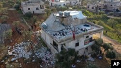 FILE - People inspect a destroyed house following an operation by the U.S. military in the village of Atmeh, Idlib province, Syria, Feb. 3, 2022. Its resident, Islamic State leader Abu Ibrahim al-Qurashi, detonated a bomb there to avoid capture, according to U.S. officials.