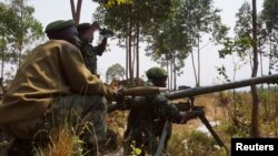 Congolese government army soldiers prepare their weapons at an attack position near Munigi, overlooking the front-line, where they are fighting against M23 rebels outside the eastern Congolese city of Goma, Jul. 15, 2013.