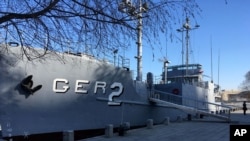 FILE - A North Korean military security guard keeps watch over the USS Pueblo in Pyongyang, North Korea, Jan. 24, 2018.