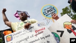 Participants chant in front of the White House in Washington, April 29, 2017, during a demonstration and march. Thousands of people gathered across the country to march in protest against President Donald Trump's environmental policies, which have included rolling back restrictions on mining, oil drilling and greenhouse gas emissions at coal-fired power plants.