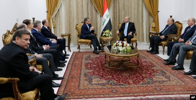 Iraq's President Barham Salih, right, meets with U.S. Energy Secretary Rick Perry, in Baghdad, Dec. 11, 2018.