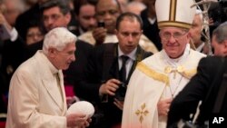Pope Francis, right, salutes Pope Emeritus Benedict XVI at the end of a consistory inside the St. Peter's Basilica at the Vatican, Feb.22, 2014.