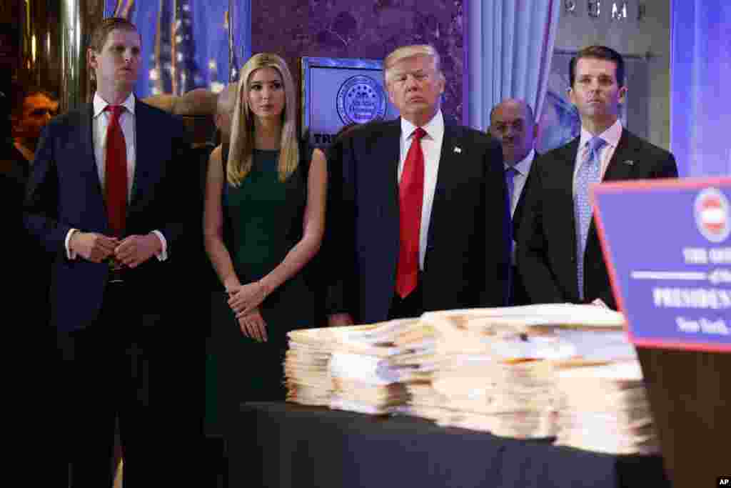 President-elect Donald Trump, accompanied by his family, arrives a news conference in the lobby of Trump Tower in New York.