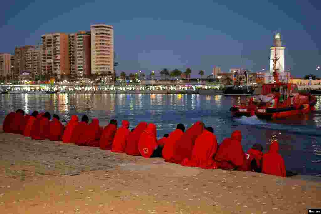 Migrants, part of a group intercepted aboard a dinghy off the coast in the Mediterranean Sea, rest after arriving on a rescue boat at the Port of Malaga, Spain.