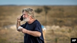 Alec Baldwin habla por teléfono en el estacionamiento frente a la Oficina del Sheriff del Condado de Santa Fe en Santa Fe, Nuevo México, luego de que fue interrogado sobre un tiroteo en el set de la película "Rust" en las afueras de Santa Fe, el jueves, 10 de octubre. 21, 2021. 