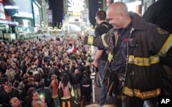 Un sapeur-pompier new yorkais saluant la foule célébrant la mort de Bin Laden à Time Square (New York)