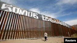 A group of activists paints the U.S.-Mexico border wall between Ciudad Juarez and New Mexico as a symbol of protest against U.S. President Donald Trump's new immigration reform in Ciudad Juarez, Mexico, Feb. 26, 2017.