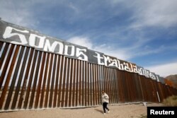 A group of activists paints the U.S.-Mexico border wall between Ciudad Juarez and New Mexico as a symbol of protest against U.S. President Donald Trump's new immigration reform in Ciudad Juarez, Mexico, Feb. 26, 2017.