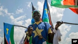 FILE - A man waves South Sudanese national flags during peace celebrations in the capital Juba, South Sudan, Oct. 31, 2018. 