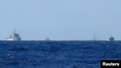 Kapal-kapal China terlihat di kejauhan menjaga Haiyang Shiyou 981, dikenal di Vietnam sebagai HD-981, anjungan minyak (kedua dari kanan) di Laut Cina Selatan (15/7/2014).