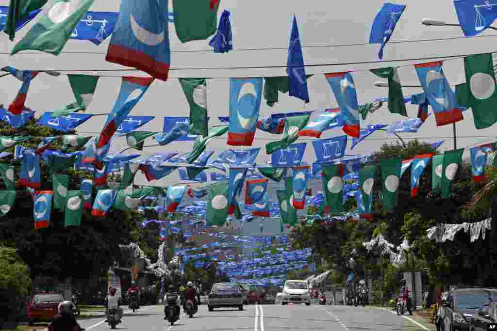 Motorists drive underneath flags of Malaysia&#39;s ruling party National Front, opposition Pan-Malaysian Islamic Party and People&#39;s Justice Party ahead of the upcoming general elections in Kuala Lumpur. 