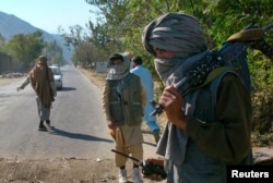 FILE - Masked Pakistani pro-Taliban militants stand at a check post in Charbagh, a Taliban stronghold, near Mingora, the main town of Pakistan's Swat Valley, Nov. 2, 2007.