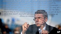 International Olympic Committee President Thomas Bach signs the Olympic truce wall during a ceremony in the Coastal Cluster Olympic Village at the 2014 Winter Olympics, in Sochi, Russia, Feb. 4, 2014.