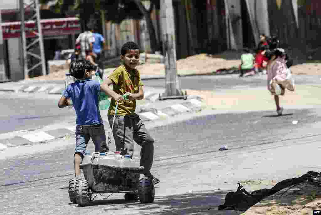 A Palestinian child pulls a cart loaded with drinking water jerricans in Khan Yunis in the southern Gaza strip.
