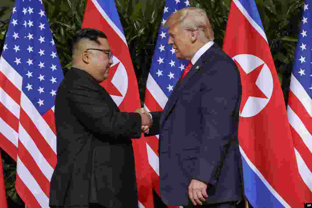 도널드 트럼프 미국 대통령과 김정은 북한 국무위원장이 12일 싱가포르 카펠라 호텔에서 역사적인 첫 미북 정상회담에 앞서 악수하고 있다.