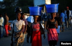 Women carry baskets with food items on their heads at a market in Blantyre, Malawi, July 10, 2017.