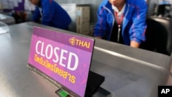 FILE - Airport staff inspect the ticketing counter at the Suvarnabhumi international airport in Bangkok.