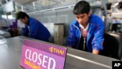 FILE - Airport staff inspect the ticketing counter at the Suvarnabhumi Airport in Bangkok.